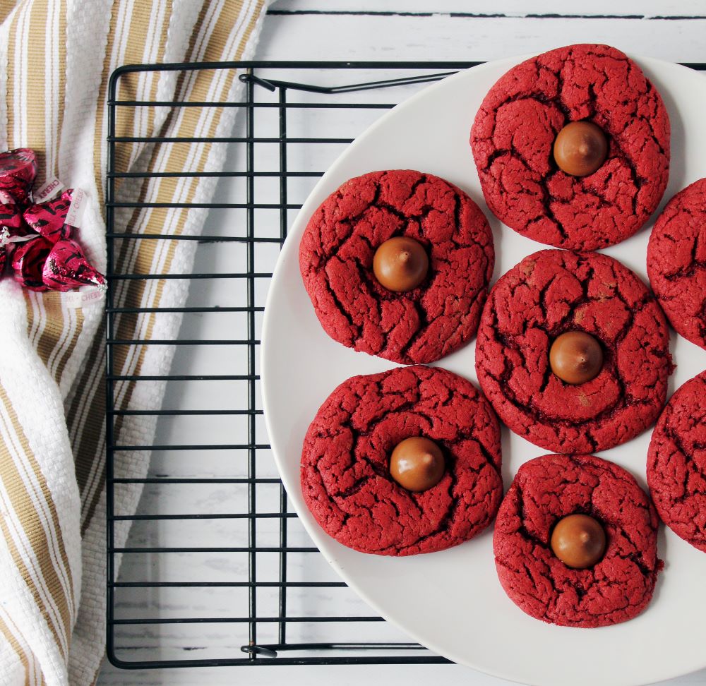 red velvet cherry kiss cookies on plate on cooling rack 1