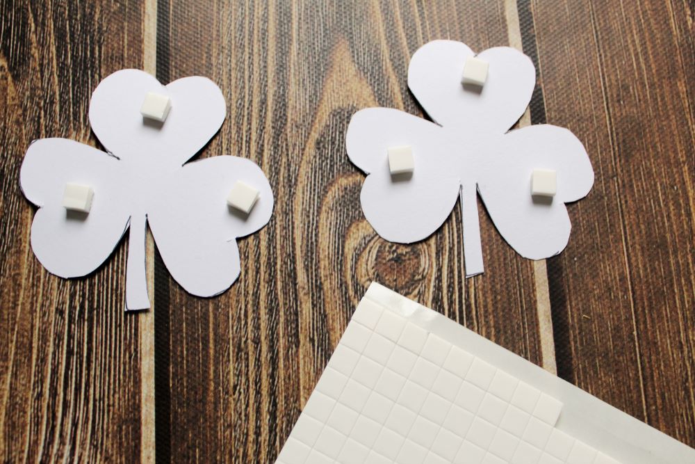 put rised sticky tabs on back of small shamrocks for diy garland 1