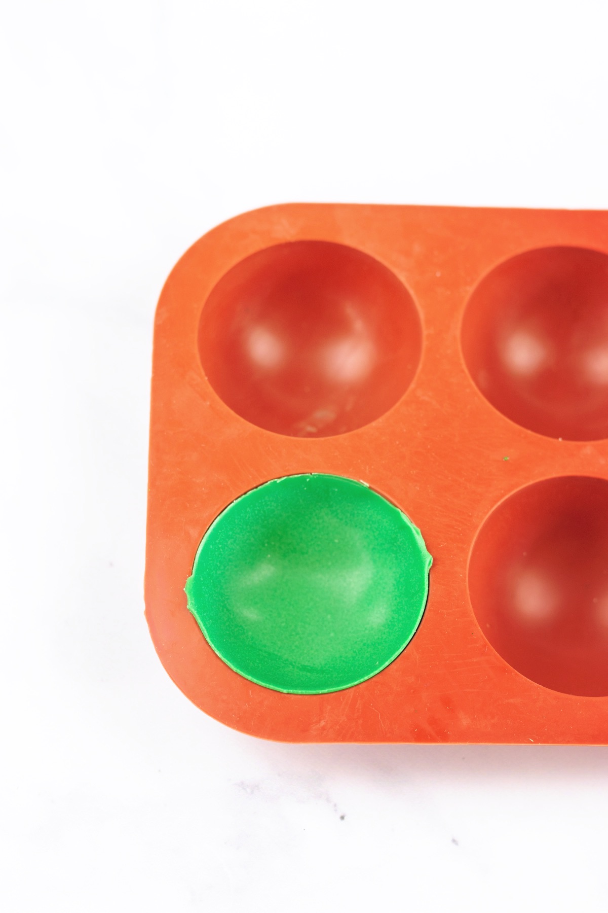 close up of a green chocolate bomb in mold