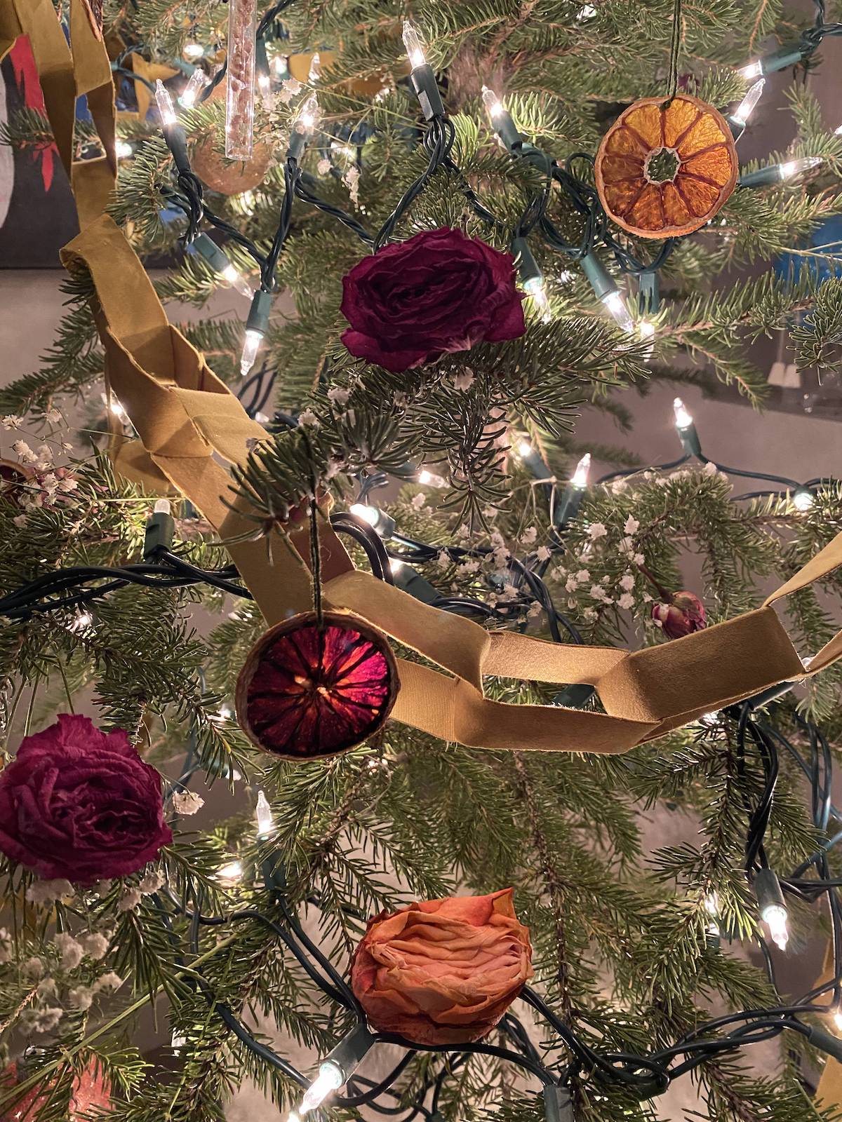 A Christmas tree with the velvet chain link garland, dried flowers and dried fruit